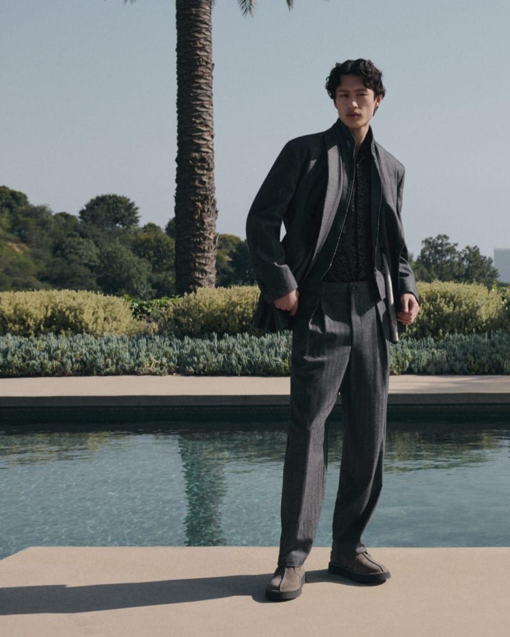 Man wearing a refined grey Giorgio Armani suit outdoors.
