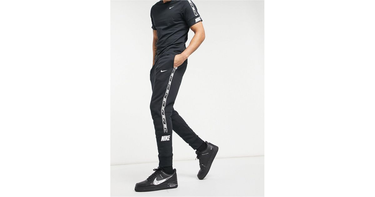 Nike logo taping cuffed joggers in black best sale