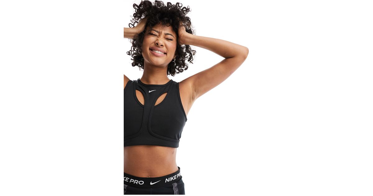 Nike Training Indy light support strappy sports bra in pink, ASOS
