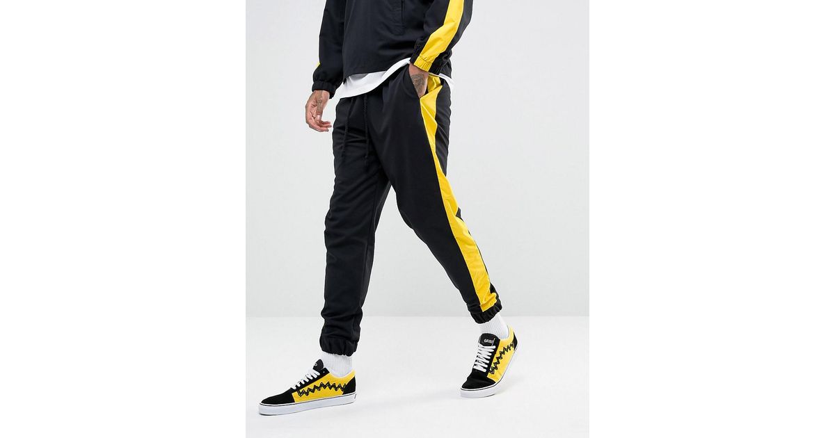 yellow track pants with black stripe