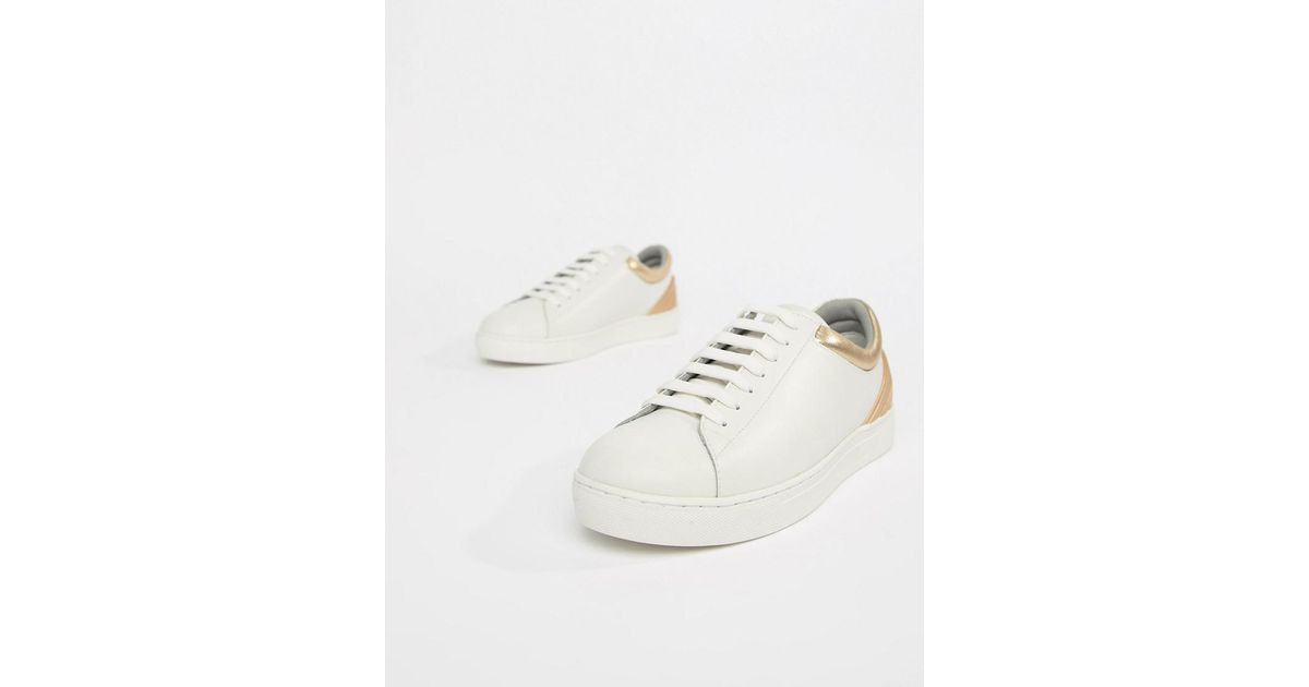white sneakers with gold trim