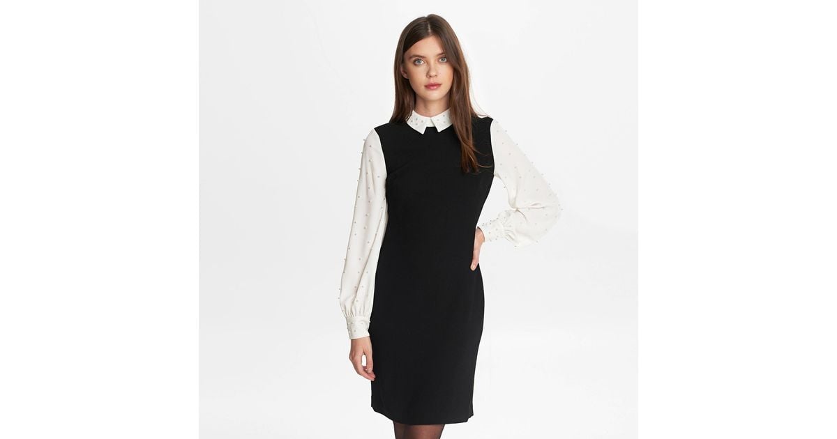 black sweater dress with pearls