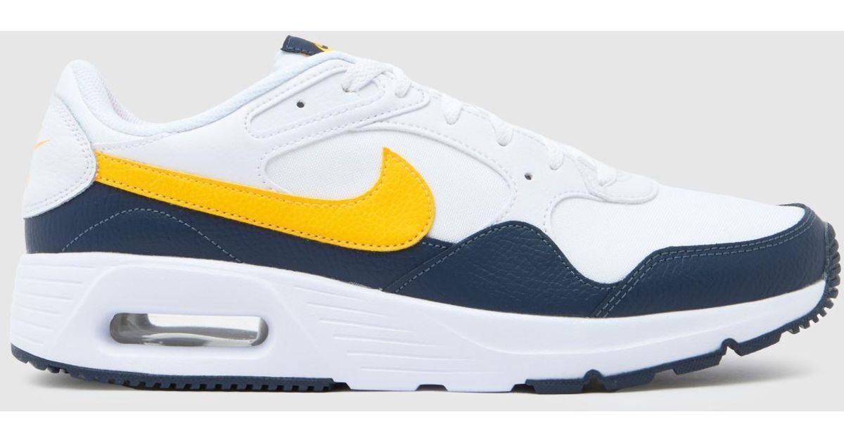 white and yellow nike trainers