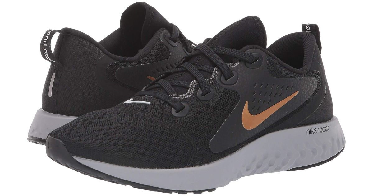 nike running legend react trainers in black and gold