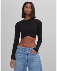 Crop top a maniche lunghe con fondo sagomato di Bershka in Nero | Lyst