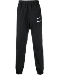 Pantalones de chándal con doble logo Swoosh Nike de Tejido sintético de  color Negro para hombre | Lyst