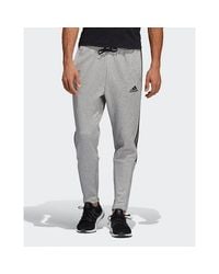 grey adidas joggers with black stripes
