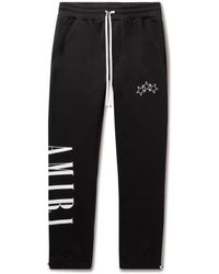 Amiri Slim-fit Tapered Logo-print Cotton-jersey Sweatpants in Black for Men - Lyst