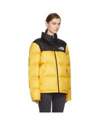 yellow and black north face puffer