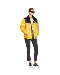 yellow and black north face puffer
