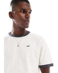 Hollister - T-shirt coupe carrée avec logo emblématique et coutures contrastantes à l'encolure - crème - Lyst