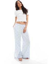 Hollister - – nachtwäsche – weite flanellhose mit mittelhohem bund, em herzmuster und logo-bund - Lyst