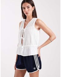 ONLY - Top Blanco Sin Mangas Con Cuello De Pico, Sobrefalda Y Lazada Delantera De Bambula De - Lyst