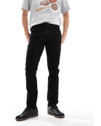 Wrangler - – larston – schmal zulaufende jeans - Lyst