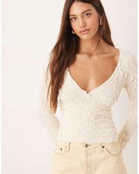 Aware - Top Color Crema Con Detalle Cruzado Y Mangas Acampanadas De Punto De Jacquard Elástico De -Blanco - Lyst