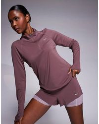 Nike - Pantalones Cortos Morado Oscuro De Talle Medio Con Diseño 2 En 1 Swift Dri-Fit De - Lyst