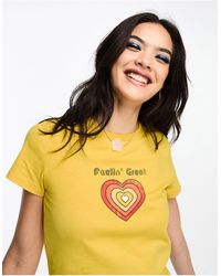 ASOS - Camiseta amarilla con diseño encogido y estampado gráfico "feeling great" estilo años 70 - Lyst