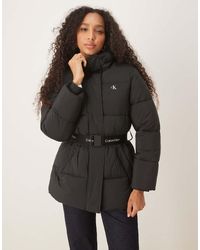 Calvin Klein - Chaqueta Acolchada Midi Negra Con Cinturón De - Lyst