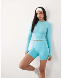 4505 - Icon short legging taille haute active 5 pouces avec poche téléphone zippée en turquoise - Lyst