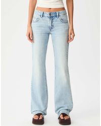 Stradivarius - – schlagjeans aus mittel-hellem denim mit niedrigem bund - Lyst