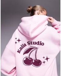 Kaiia - Studio - sweat à capuche d'ensemble oversize avec imprimé cerises contrastant au dos - pastel - Lyst