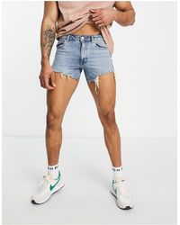 ASOS - Short court en jean style années 90 avec déchirures et ourlet brut - moyen délavé - Lyst