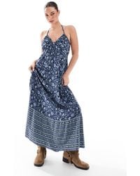 Hollister - Vestido Largo Azul Marino Con Estampado De Cachemir, Cuello Halter Y Detalle Escalonado En El Bajo De - Lyst