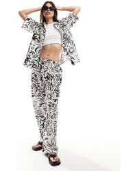Iisla & Bird - Pantaloni da mare ampi neri e bianchi con grafica stampata - Lyst