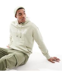 Calvin Klein - Sudadera color crema cómoda con capucha y logo hero - Lyst