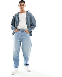 ASOS - Jeans oversize affusolati lavaggio medio - Lyst