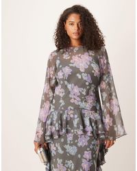Robe à volants superposés. Décolleté rond et manches 3/4. Coupe évasée