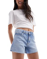 Calvin Klein - Pantaloncini di jeans a vita medio alta lavaggio chiaro - Lyst