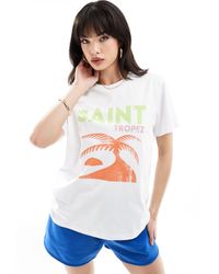 ASOS - T-shirt regular fit bianca con stampa saint tropez su licenza - Lyst
