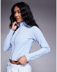 Nike - Gym life - top zippé à manches longues et logo virgule - clair - Lyst