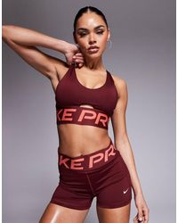 Nike - Sujetador Deportivo Escotado De Sujeción Baja Dri-Fit Indy De Nike Pro Training-Rojo - Lyst