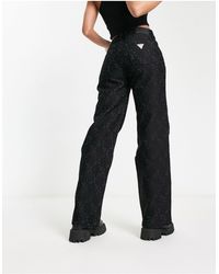Guess - Jeans a fondo ampio neri con logo - Lyst