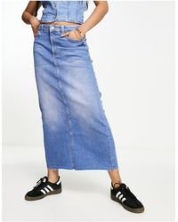 Bershka - Jupe mi-longue en jean avec ourlets bruts - moyen délavé - Lyst