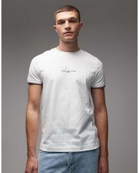 Tommy Hilfiger - T-Shirt Bianca Con Logo E Righe A Contrasto Sui Bordi - Lyst