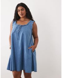 ASOS - Asos design curve denim-minikleid mit rüschen-details und taschen - Lyst