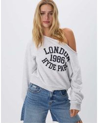 Stradivarius - Sweatshirt Met Blote Schouder En Grafische Print - Lyst