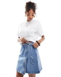Vero Moda - Mini-jupe portefeuille en jean - moyen - Lyst