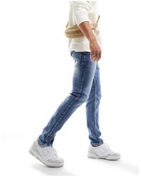 ASOS - Jeans slim elasticizzati lavaggio tinto medio - Lyst