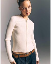 Stradivarius - Gilet en maille avec capuche en fausse fourrure - vanille - Lyst