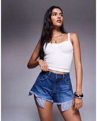 ASOS - Pantalones Cortos Vaqueros Con Lavado Medio, Bolsillos Bajos Visibles Y Detalles Rasgados De -Azul - Lyst