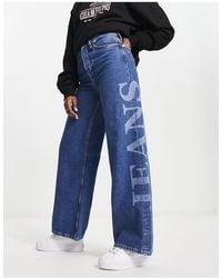 Tommy Hilfiger - Jeans a fondo ampio lavaggio medio a vita alta con logo - Lyst