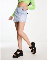Bershka - Mini-jupe en jean à ceinture minimaliste et ourlet brut - moyen - Lyst
