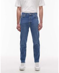 TOPMAN - Vaqueros Azules Elásticos De Corte Tapered Con Lavado Medio De - Lyst