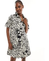 Monki - Robe chemise courte et boutonnée à imprimé estival avec manches courtes et col - noir et blanc - Lyst