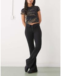 Monki - Low Rise Flared Trousers With Fold Down Waist Detail - Lyst