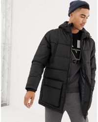 Lang geschnittene, schwarze Pufferjacke mit Kapuze Lang geschnittene, schwarze Pufferjacke mit Kapuze